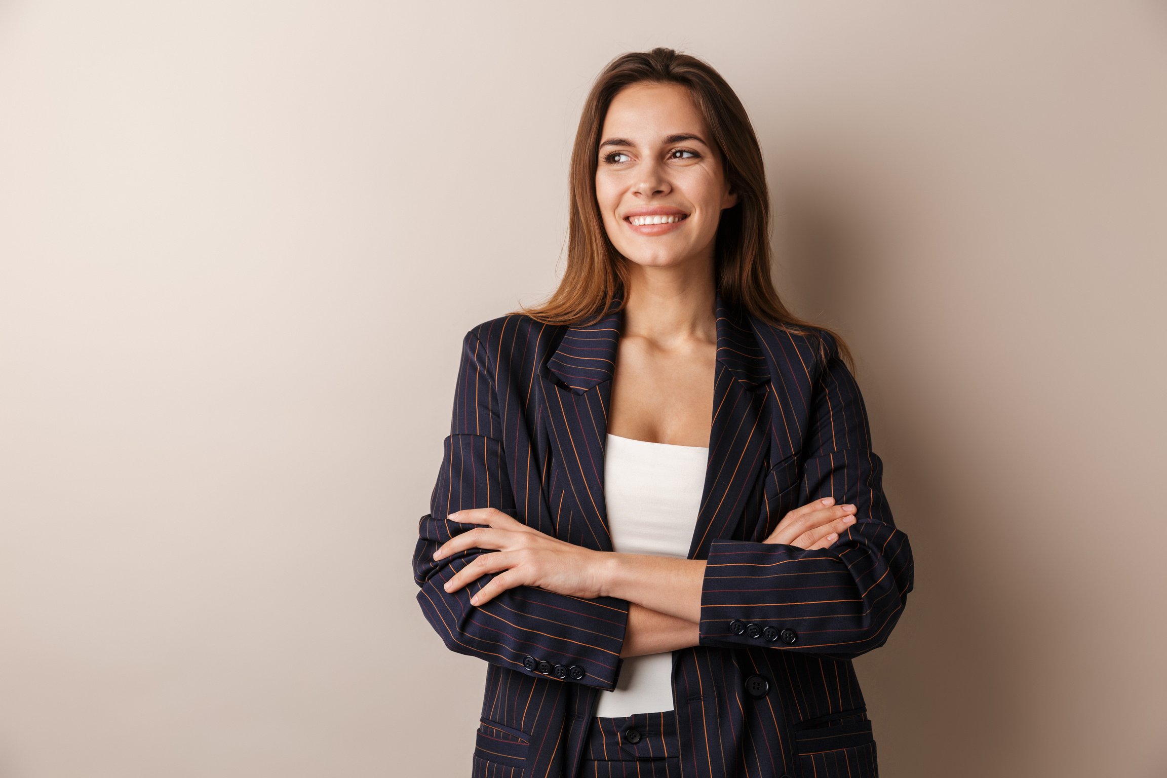 Photo of Joyful Businesswoman in Formal Suit Laughing with Arms Crossed