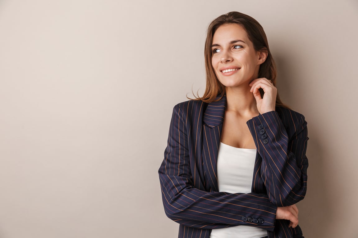 Photo of Joyful Businesswoman in Formal Suit Smiling and Looking Aside